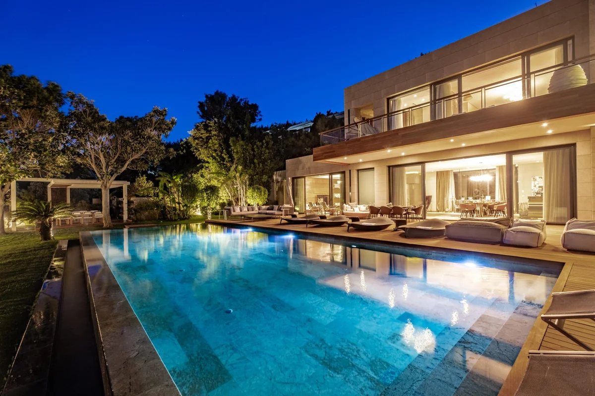 Illuminated luxury villa and swimming pool at dusk