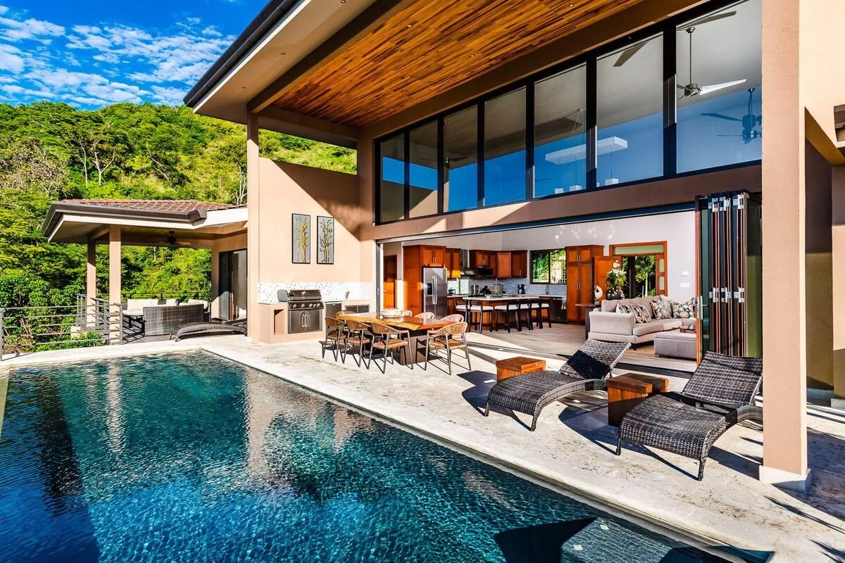 Modern villa with a private swimming pool, sun loungers and an open dining terrace