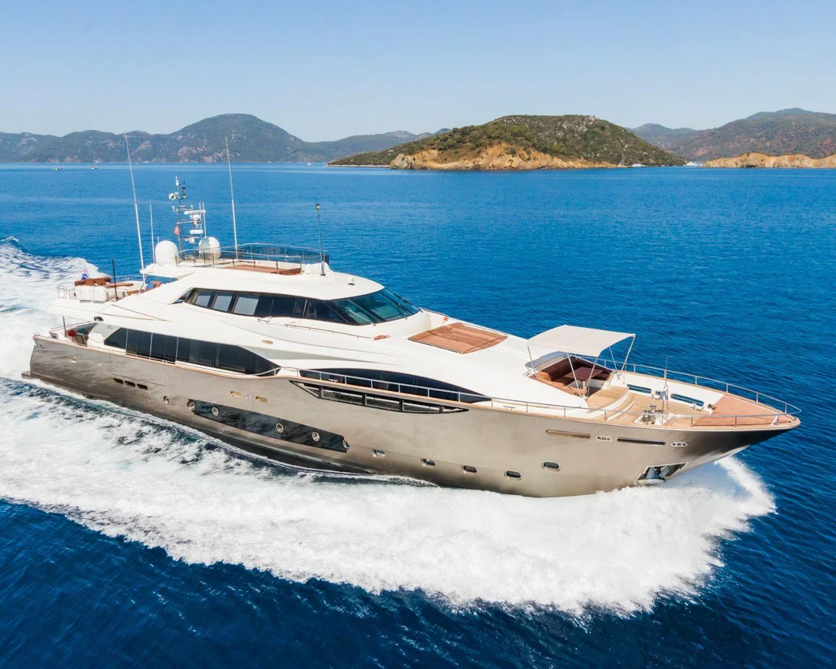 Motor yacht cruising through blue water beside coastal islands
