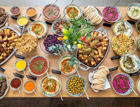 Overhead view of a mezze spread with dips, salads, breads and olives